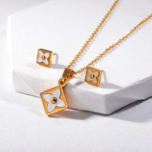 Conj dorado collar y arete acril bco trebol
