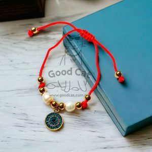 Pulsera roja con dijes y bolita de perlas